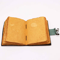 Cuaderno de cuero Buda 7 Chakras de 12,5x17,5cm abierto, mostrando sus páginas rústicas de papel artesanal en tono sepia, cosido a mano. Su diseño evoca un estilo vintage y es ideal para escritura, dibujo o como diario espiritual