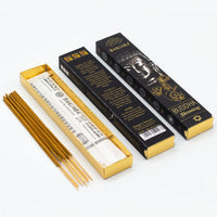 Varitas de incienso Banjara Buddha Bendición (Blessing) en su caja dorada abierta, mostrando el contenido de varillas y el envoltorio. Al lado, dos cajas de incienso cerradas, una con la imagen de Buda y el nombre 'Buddha Blessing', perfecto para la meditación y crear un ambiente sereno.