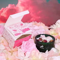 vela aromatica con cristales cuarzo rosa rodeada de petalos de rosa blanca